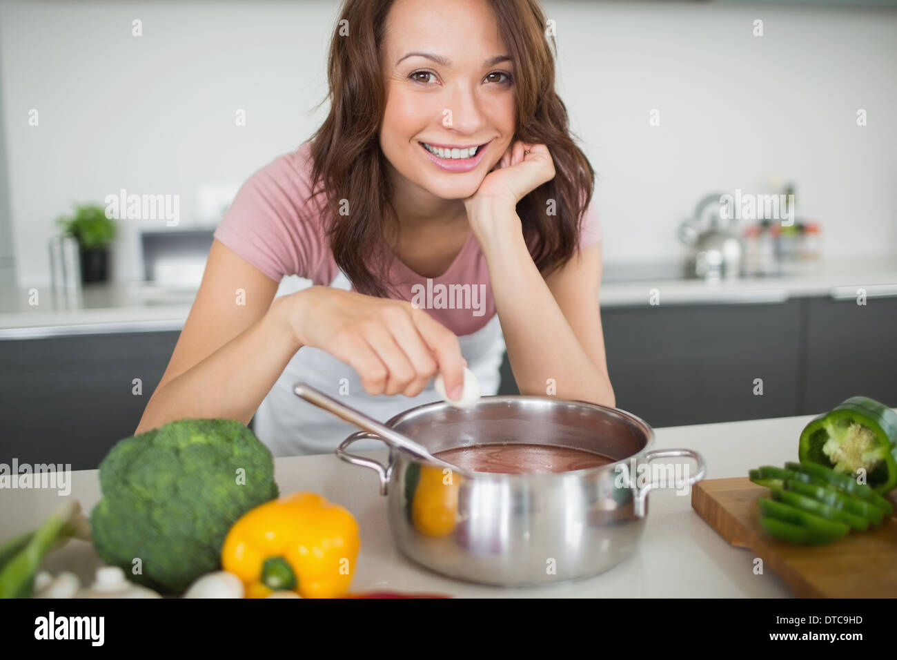 Portrait of smiling woman preparing food in kitchen Banque D'Images