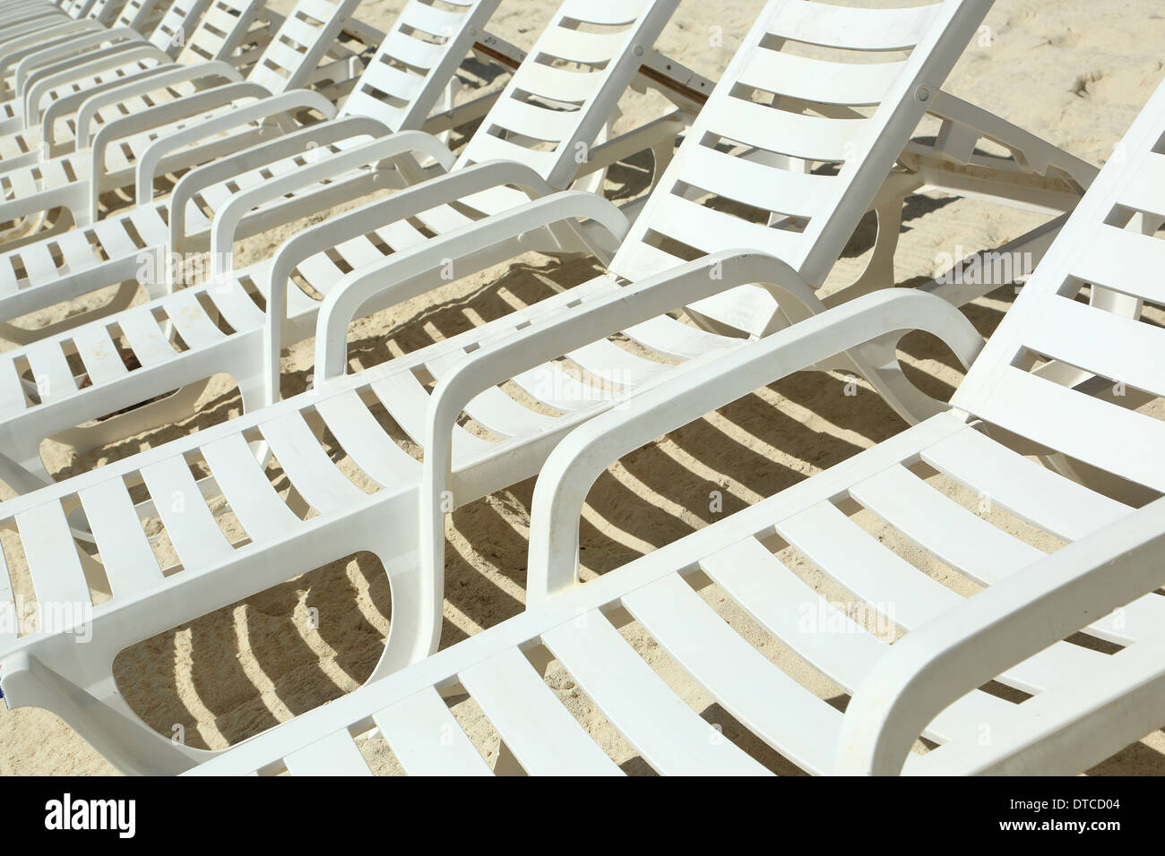 Une rangée de chaises de plage de sable blanc sur la plage Banque D'Images