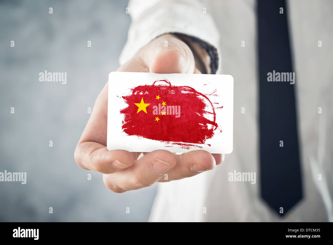 Chinese Businessman holding carte d'affaires avec la Chine Drapeau. La coopération internationale, les investissements, les occasions d'affaires Banque D'Images