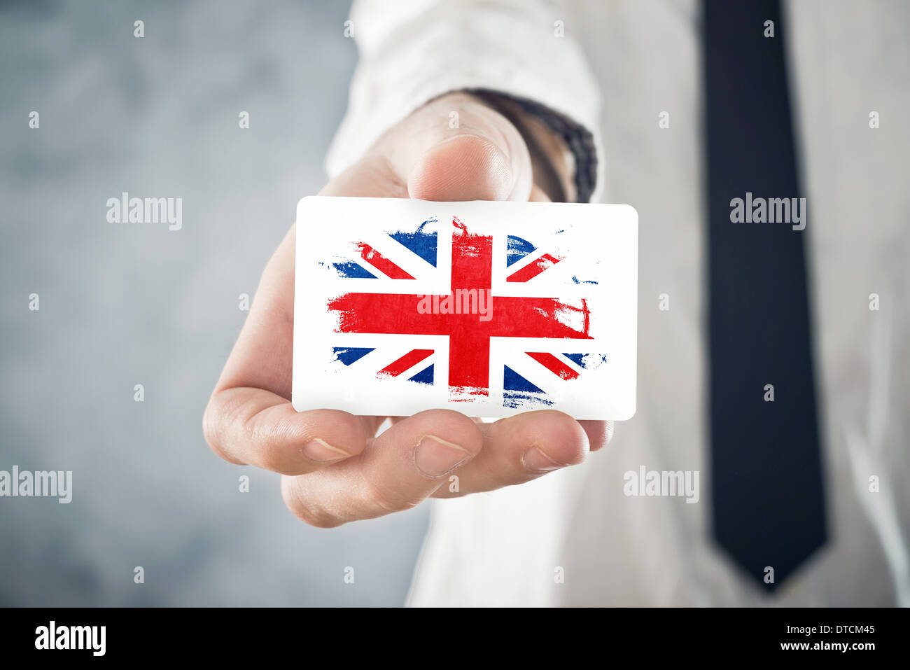 Businessman holding britannique carte d'affaires avec la Grande-Bretagne Drapeau. La coopération internationale, les investissements, l'occasion d'affaires Banque D'Images