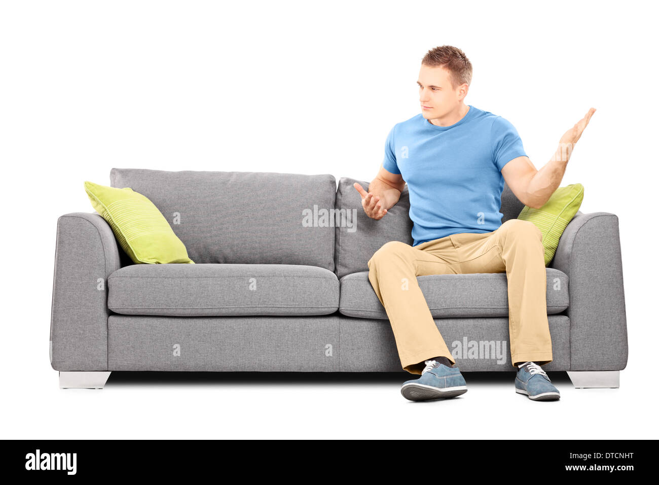 Angry Man sitting on couch et balançant sa main violemment Banque D'Images