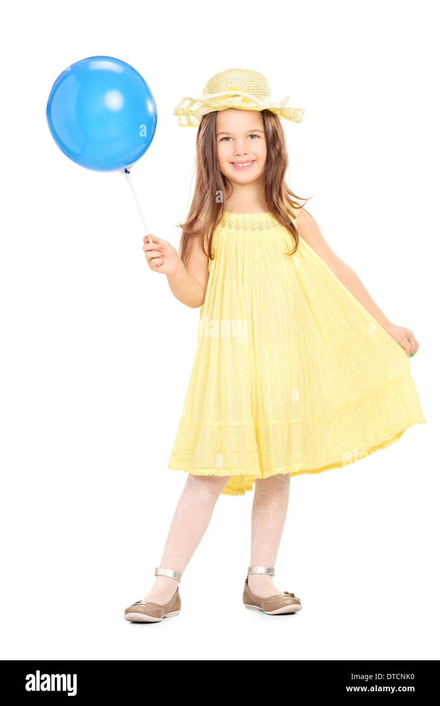 Portrait d'une adorable petite fille en robe jaune tenant un ballon bleu Banque D'Images