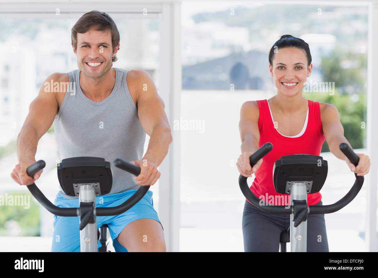 Smiling young couple working out at spinning class Banque D'Images