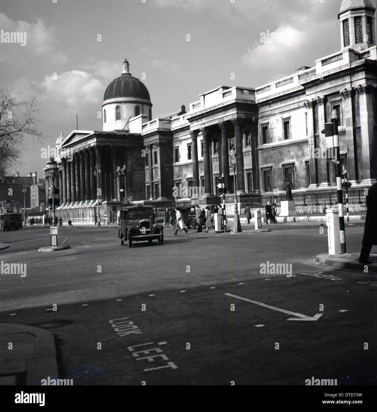 1950, historique, un taxi de l'époque qui passe devant la buideur couvert de suie de la National Gallery, Trafalgar Square, Westminster, Londres, Angleterre, ROYAUME-UNI. Banque D'Images