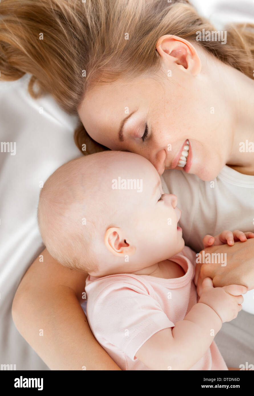 Jeune mère et bébé au lit Banque D'Images