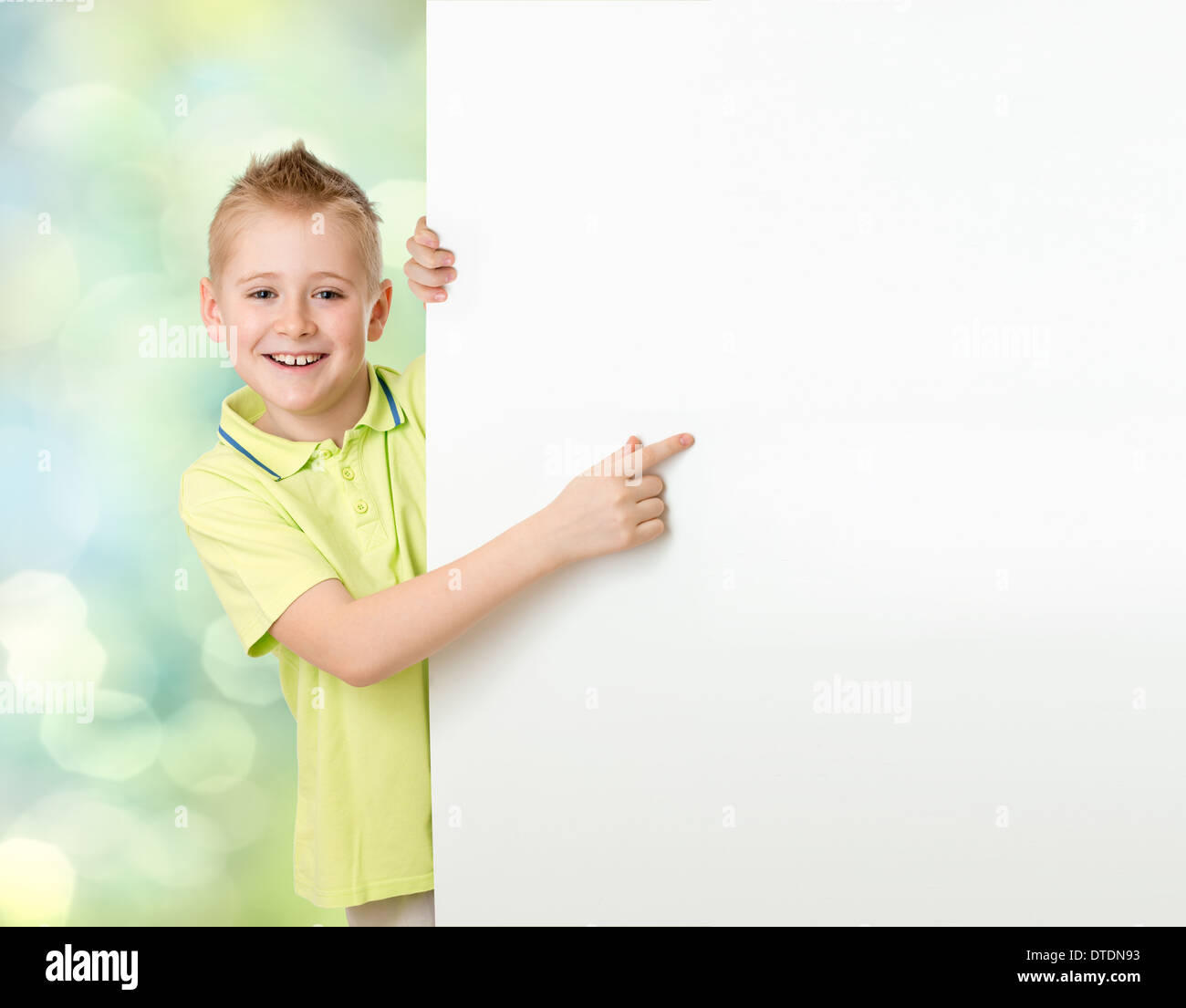 Beau garçon en pointant sur bannière publicitaire vierge Banque D'Images