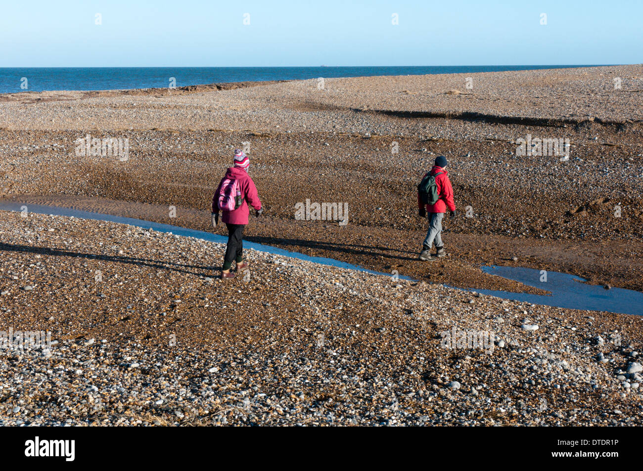 Les promeneurs sur la North Norfolk Coast Path traverser une brèche dans le Shingle Spit à Salthouse causés par les inondations. Banque D'Images