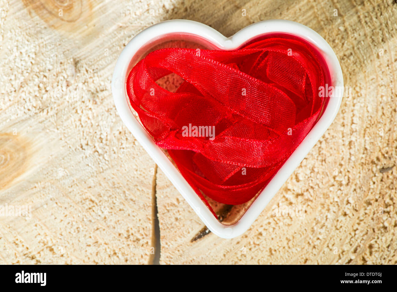 Forme de coeur fait de textile rouge sur base de bois Banque D'Images