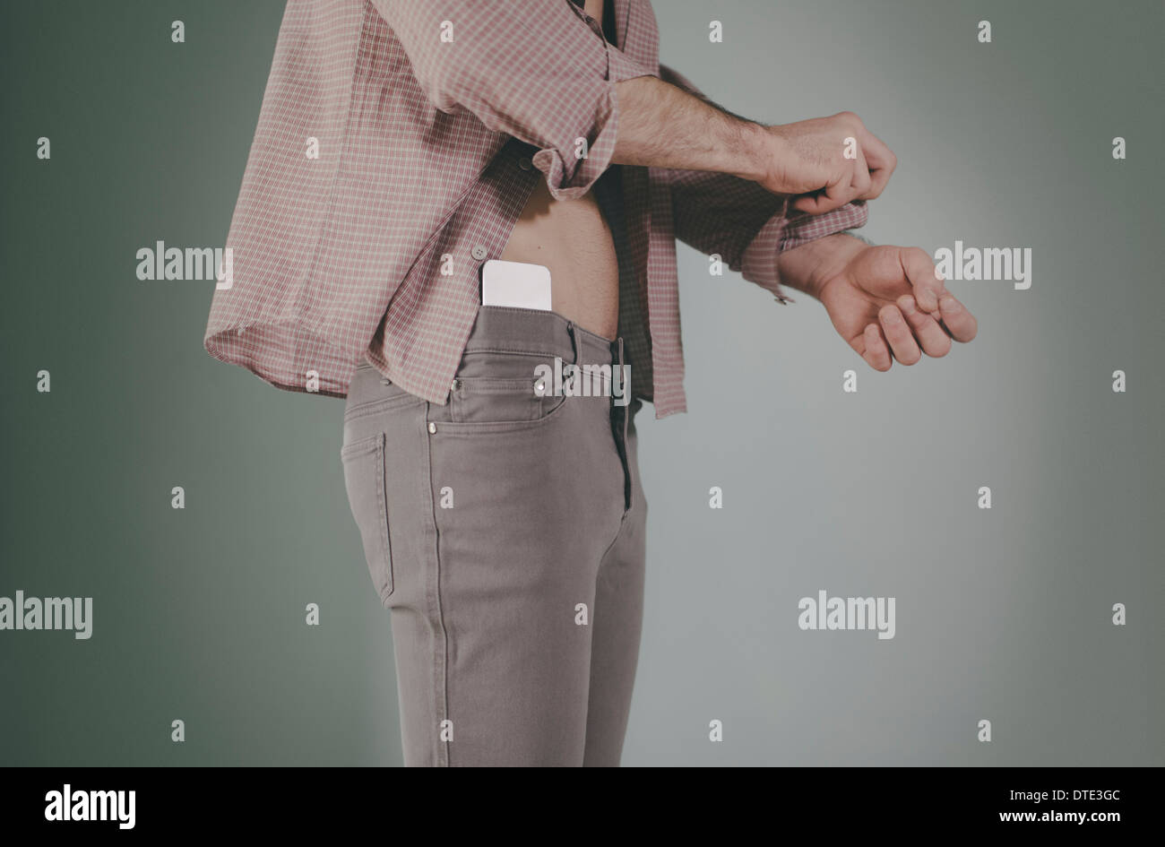 Partie d'une série montrant différentes façons on est porteur d'un smartphone, nichée dans la taille des jeans serrés. Banque D'Images