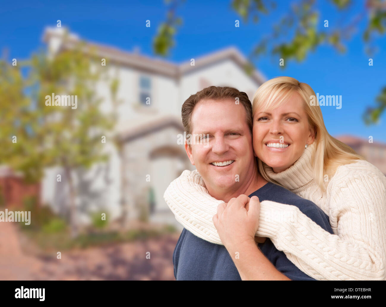 Heureux Couple Hugging in front of a Beautiful House. Banque D'Images