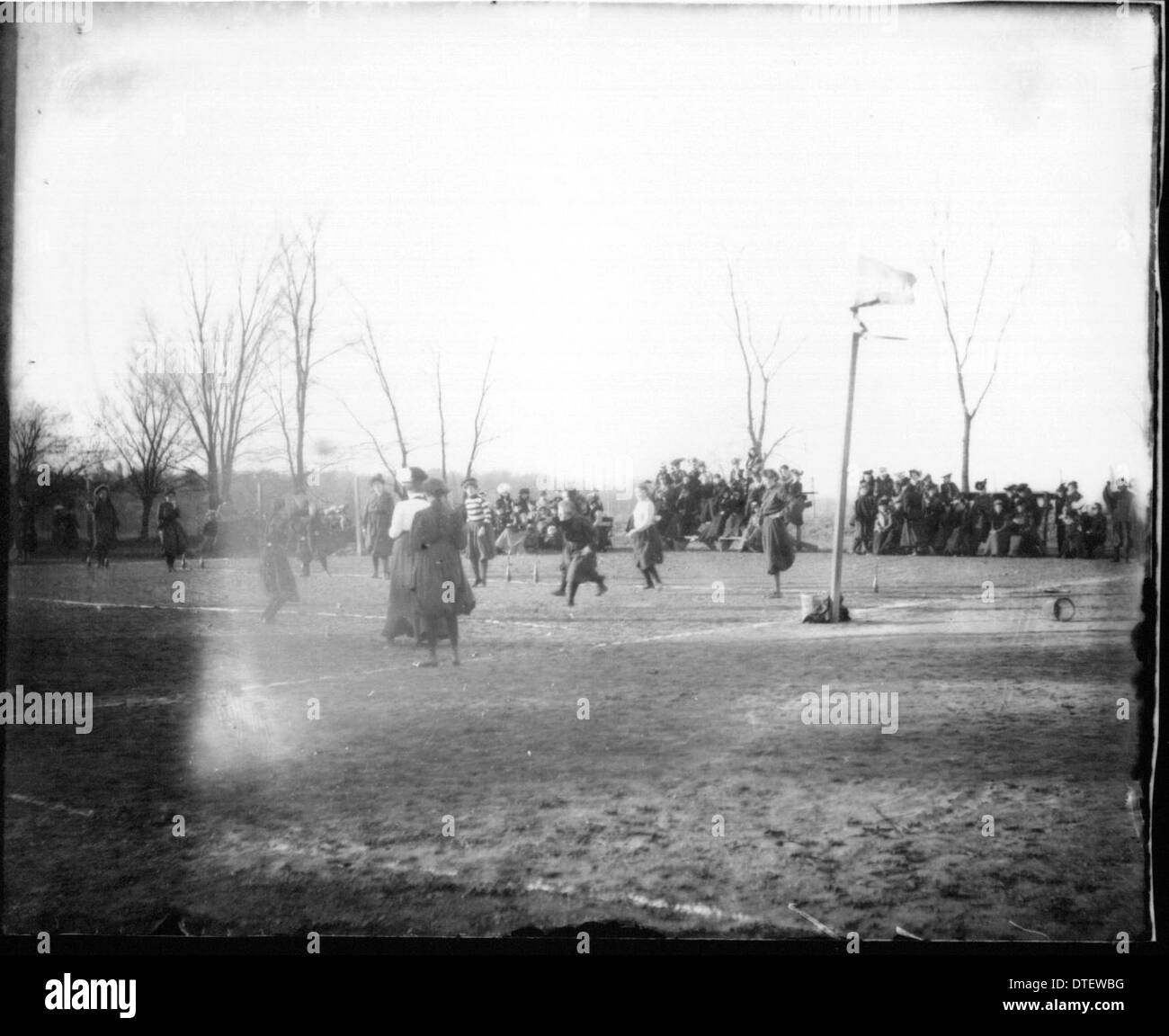 Une photographie montrant des femmes jouant à des jeux en plein air avec une foule regardant, capturant un moment dans le sport féminin et la vie universitaire. L'événement met en lumière la participation sportive et le rôle croissant des femmes dans le sport à l'époque. Banque D'Images