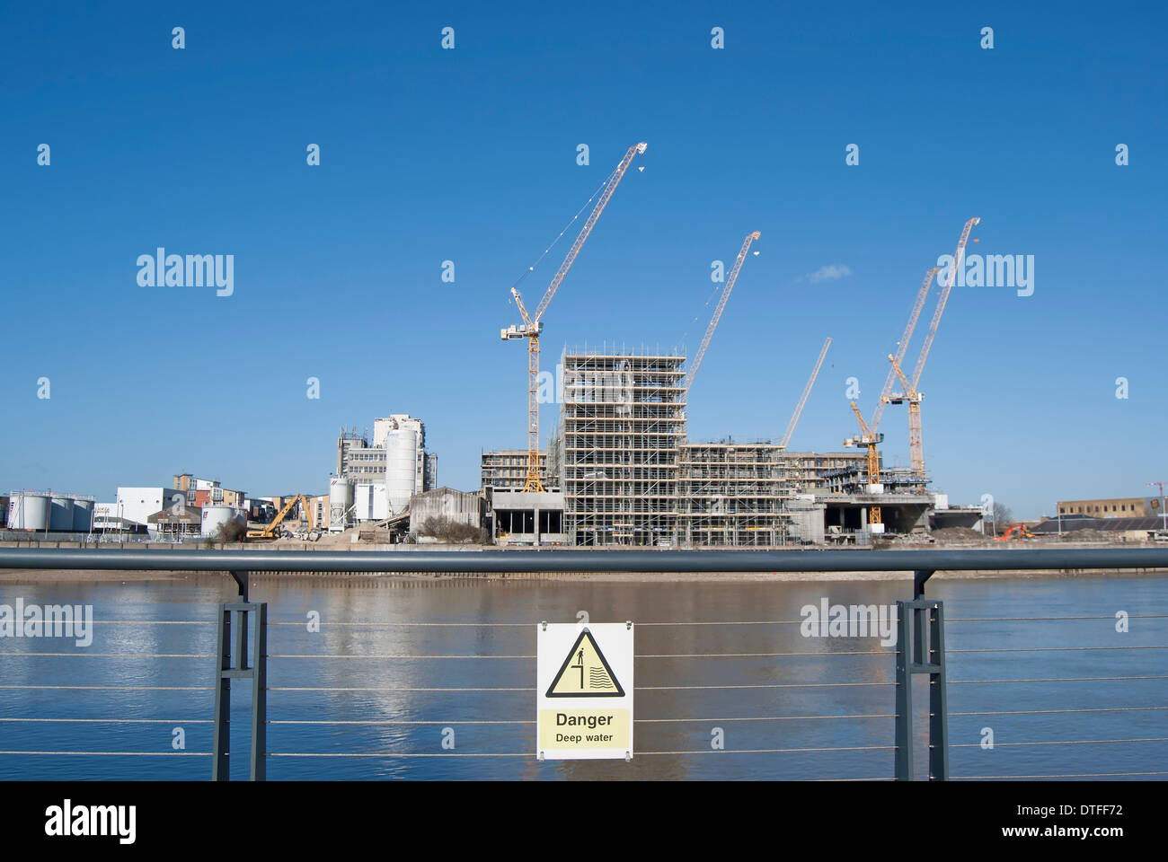 Vue sur la Tamise à partir de battersea atteindre vers un chantier avec des grues, signe de danger eau profonde en premier plan Banque D'Images