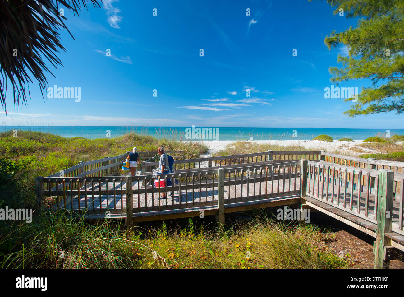 USA Floride Sarasota FL Longboat Key plus mature couple marche sur une plage à pied à travers les dunes protégées de l'exploitation des sables bitumineux Banque D'Images