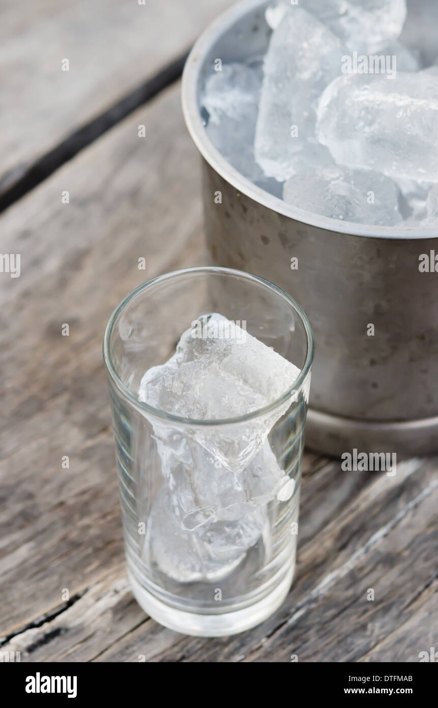 Verre avec des glaçons et seau à glace rempli de glaçons Banque D'Images