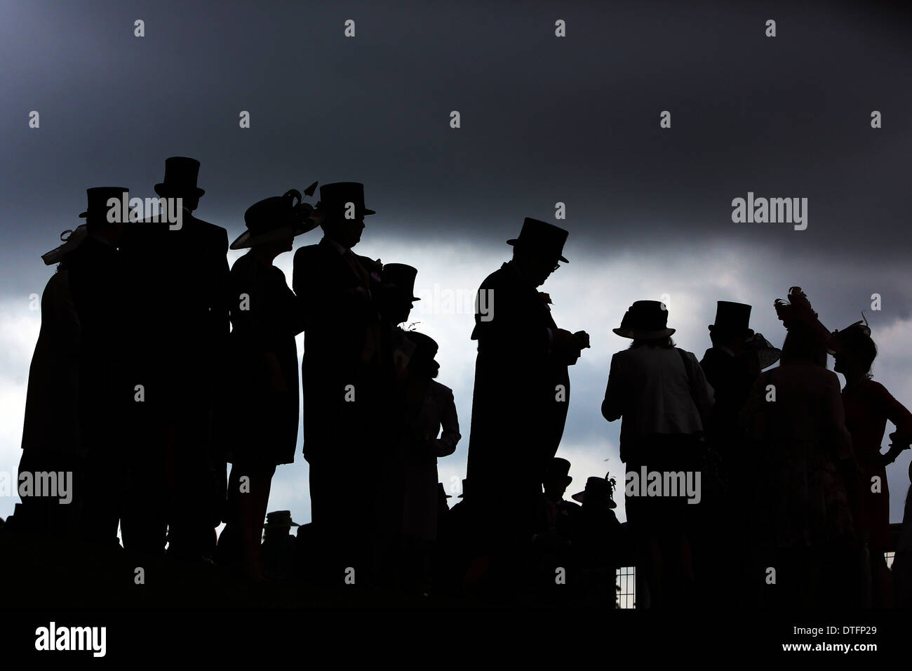 Ascot, Royaume-Uni, silhouette, les gens habillés en face d'un ciel sombre Banque D'Images
