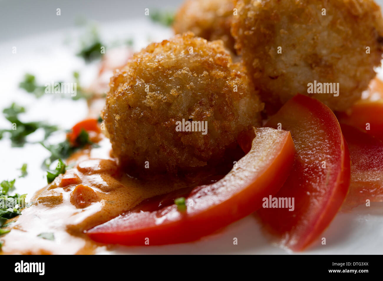 Plat de boulettes de riz Frites enrobées de chapelure, Arancini, avec les tranches de tomate on white plate Banque D'Images