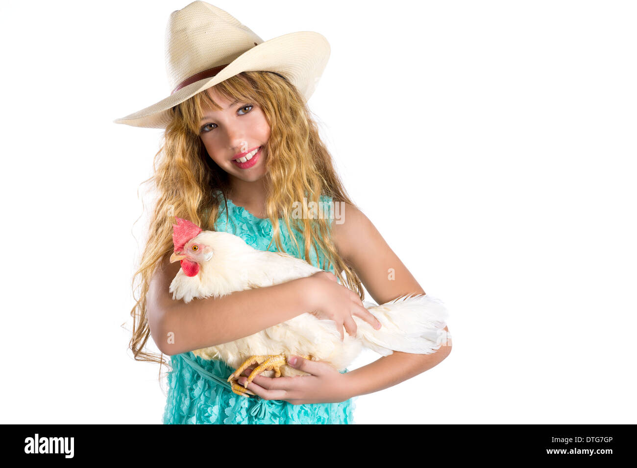 Kid girl blonde farmer holding white hen sur les armes avec cowboy hat Banque D'Images