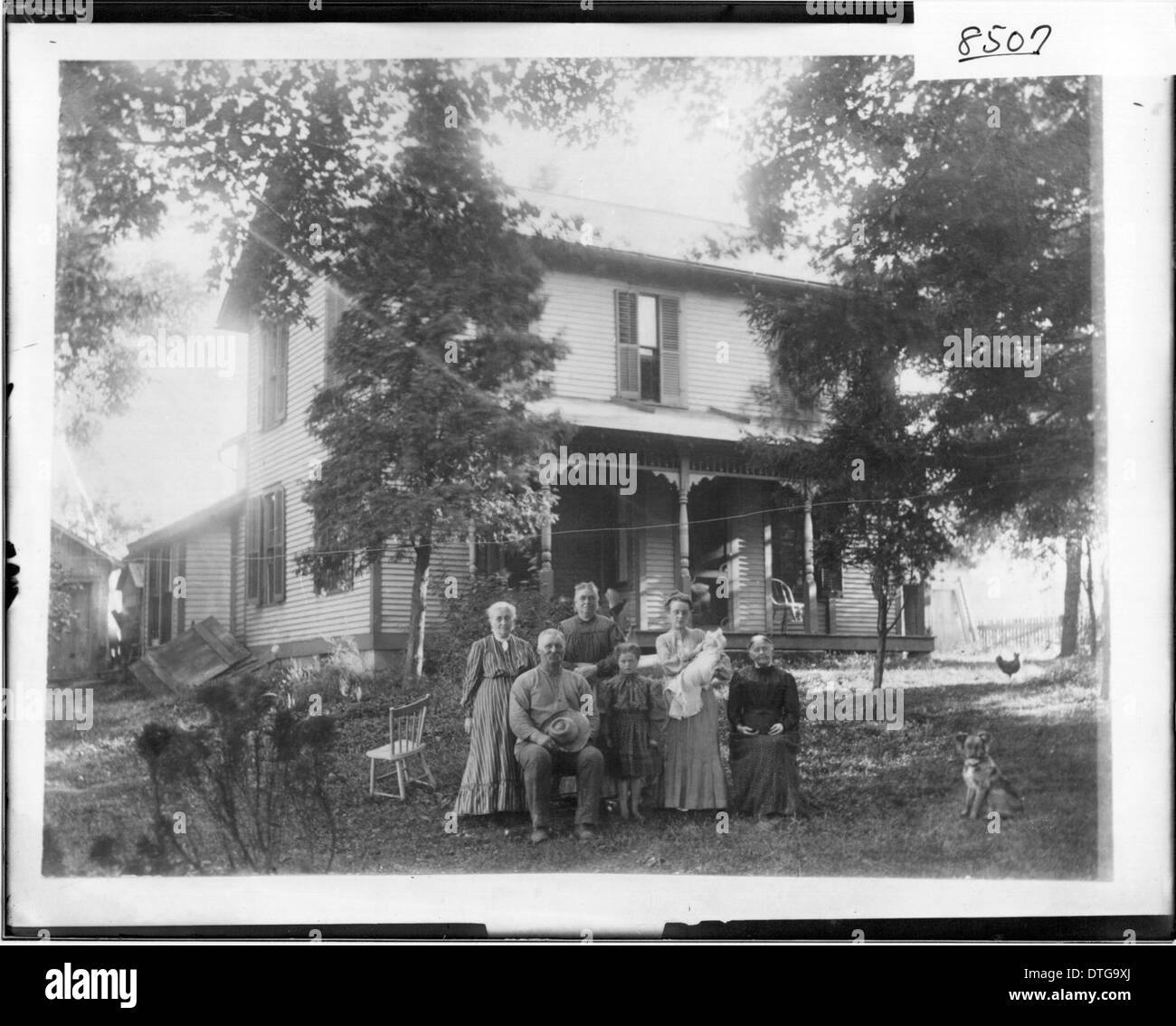 Cette photographie historique de 1908 montre la famille J.H. Spencer devant leur maison, capturant un moment de la vie à la campagne avec des enfants, des adultes et des animaux. La photographie reflète la vie familiale rurale au début du XXe siècle en Amérique. Banque D'Images