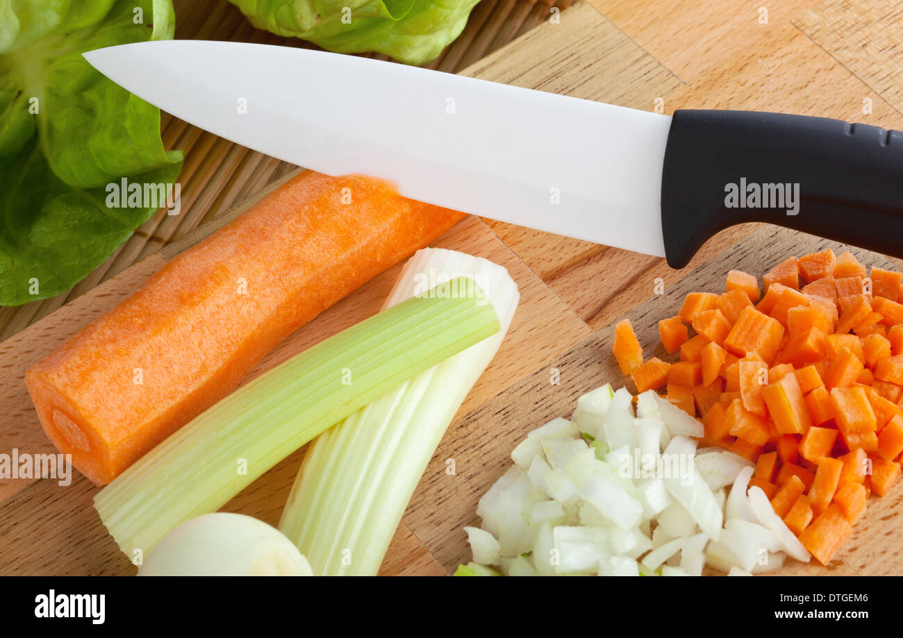 Couteau en céramique avec planche à découper en bois sur soffritto Banque D'Images