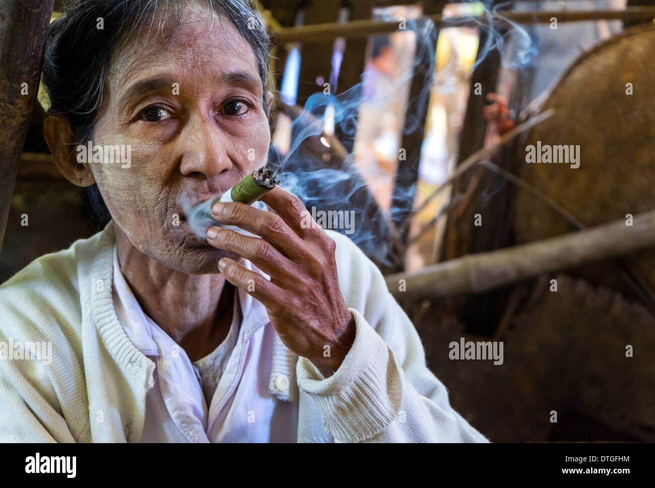 Vieille Femme birmane de fumer un cigare dans le marché de Nyaung U près de Bagan au Myanmar Banque D'Images