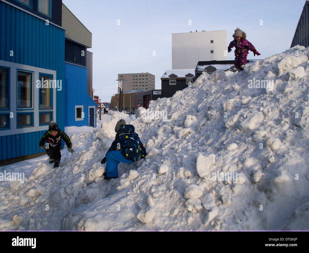 Centre de Nuuk, sur la rue principale, ung les garçons et les filles jouent sur une montagne de neige. Banque D'Images