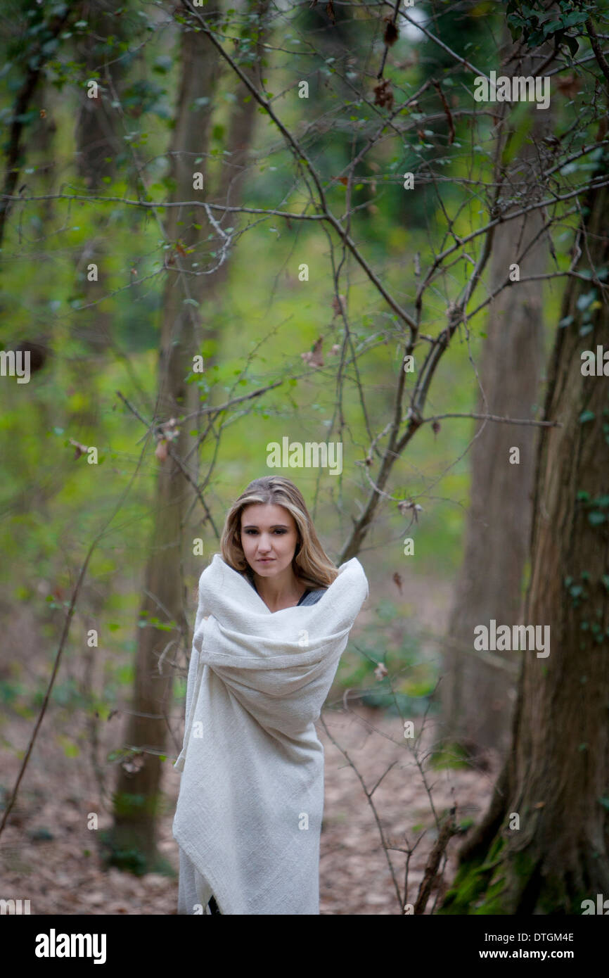 Femme dans une forêt enveloppée d'une couverture Banque D'Images