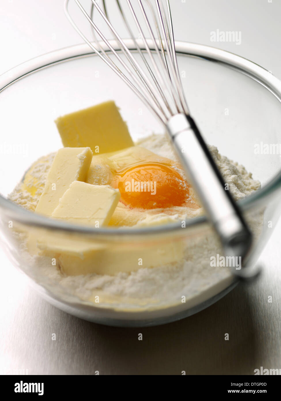 Mélanger la farine,le beurre et l'œuf entier dans un bol avec un fouet Banque D'Images