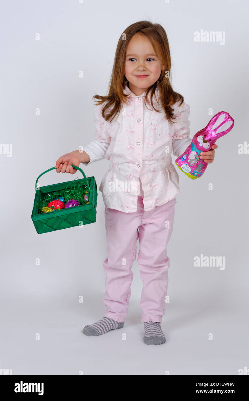 Girl holding an Easter basket et un lapin de Pâques au chocolat Banque D'Images