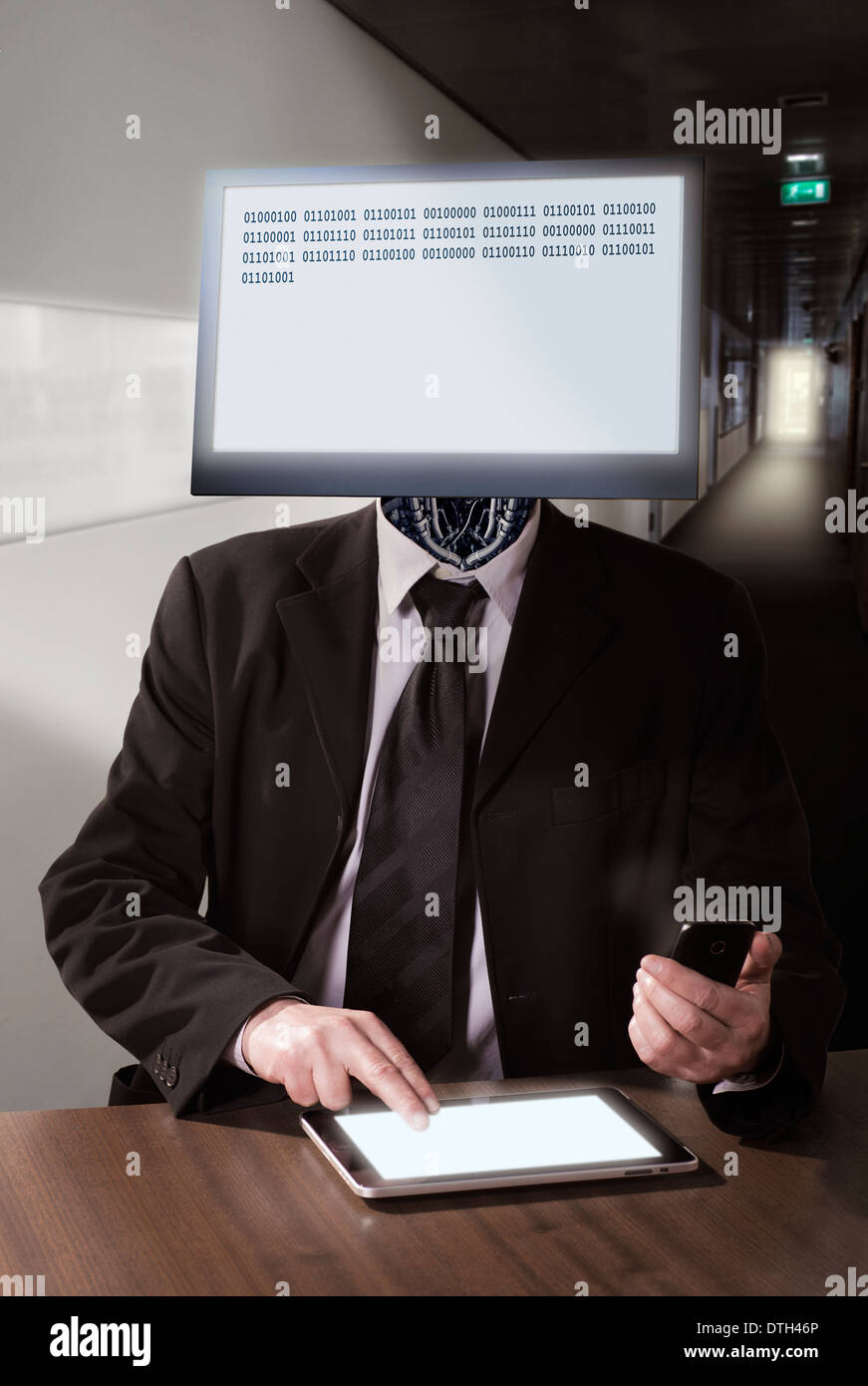 Un cyborg avec le moniteur de l'ordinateur comme un chef assis à un bureau. Banque D'Images