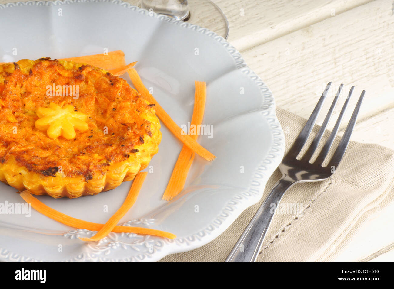 Mini quiche végétarienne avec carottes servi sur une assiette de porcelaine gris Banque D'Images