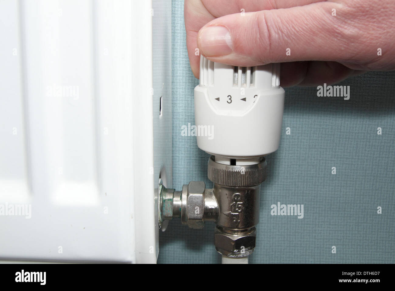Tourner la vanne de radiateur homme/chauffage contrôler jusqu'en bas dans  le salon de la maison, England, UK (Modèle 1992 Photo Stock - Alamy