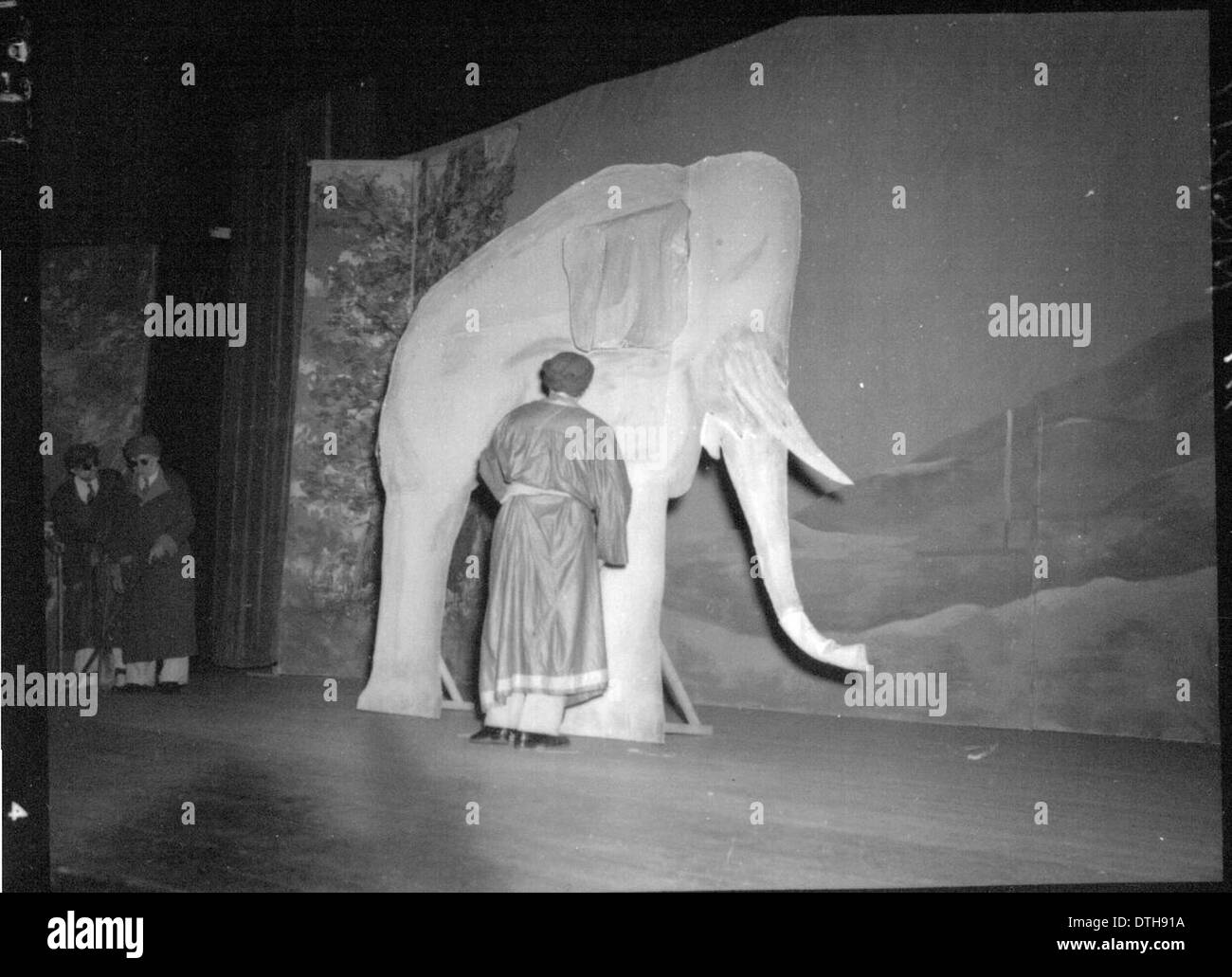 Une production théâtrale mettant en vedette un homme en costume aux côtés d'un éléphant accessoire de scène, probablement tiré d'une performance historique. La photographie reflète l'utilisation d'accessoires de scène et de costumes élaborés dans des spectacles du passé, possiblement liés aux programmes d'éducation des femmes à l'Université de Miami. Banque D'Images