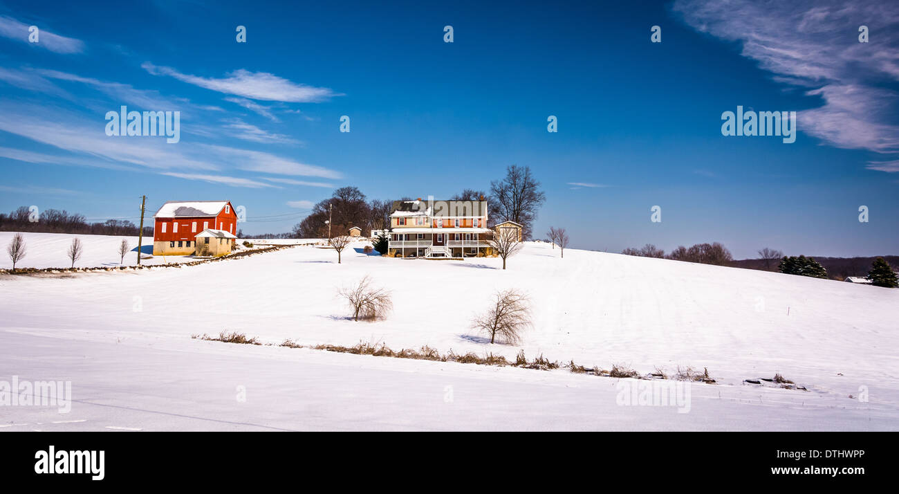 Maison et grange sur la neige a couvert les champs agricoles en milieu rural Carroll County, Maryland. Banque D'Images