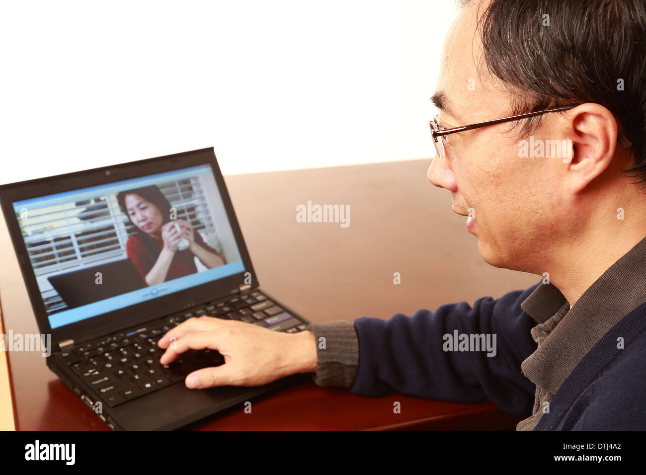 L'homme asiatique parlant avec une femme asiatique, par téléconférence. Banque D'Images