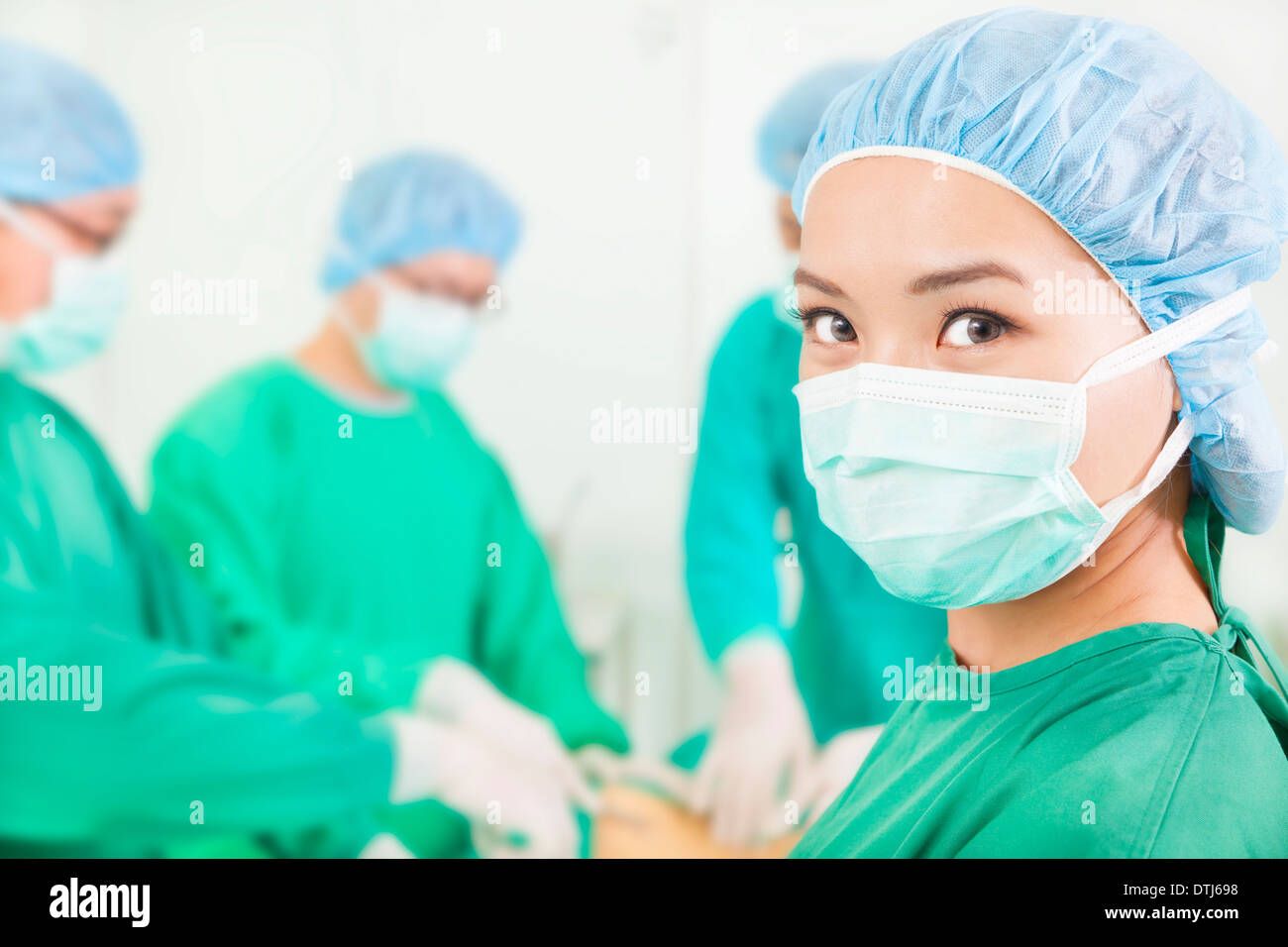 Femme chirurgien en collaboration avec équipe dans une salle de chirurgie à l'hôpital Banque D'Images