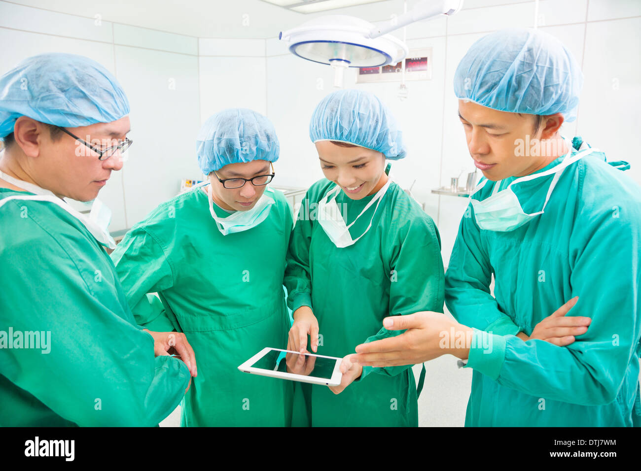 Chirurgiens discuter avec tablette en salle d'opération à l'hôpital Banque D'Images