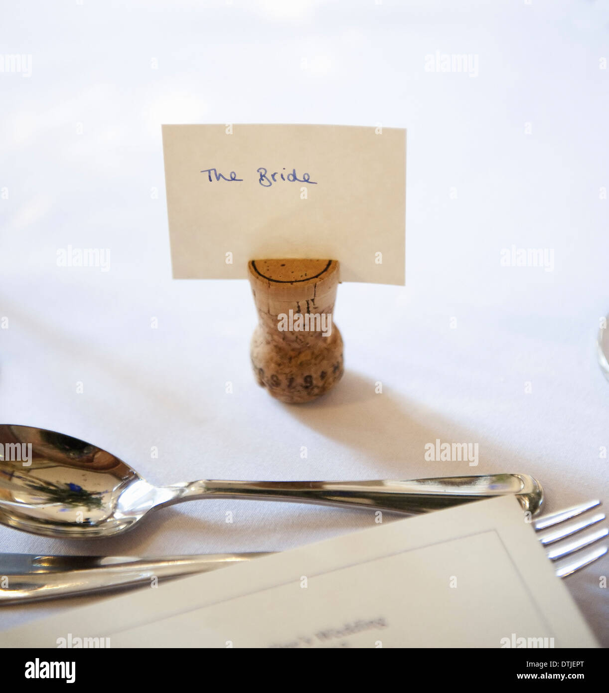 Haut de la table à un banquet de mariage une l'envers liège avec une étiquette de nom pour la mariée fourchette et cuillère en argent Angleterre Banque D'Images