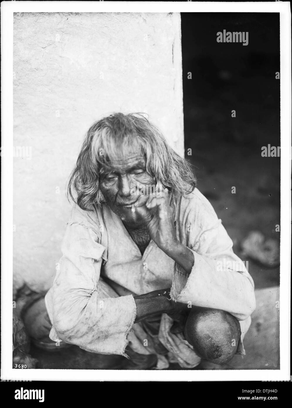 Photographie d'un homme indien Hopi âgé à l'extérieur, fumant une cigarette, reflétant la vie des Amérindiens au début du XXe siècle. Banque D'Images
