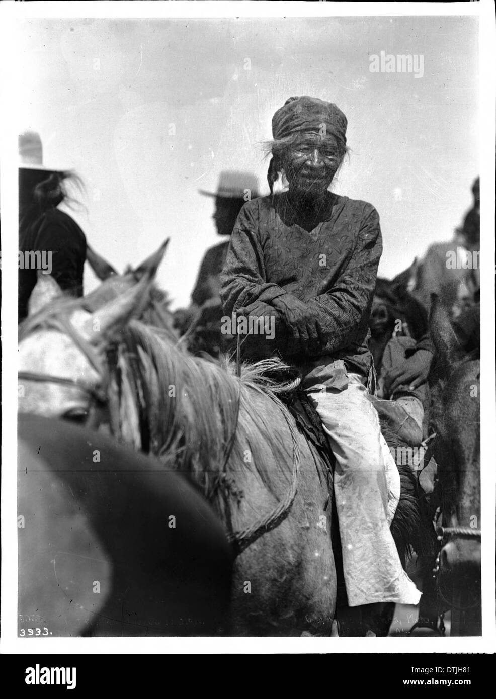 Un vieil indien Navajo assis sur un cheval vers 1900. La photographie dépeint un moment de force tranquille, montrant l'homme en tenue traditionnelle avec son cheval. Banque D'Images