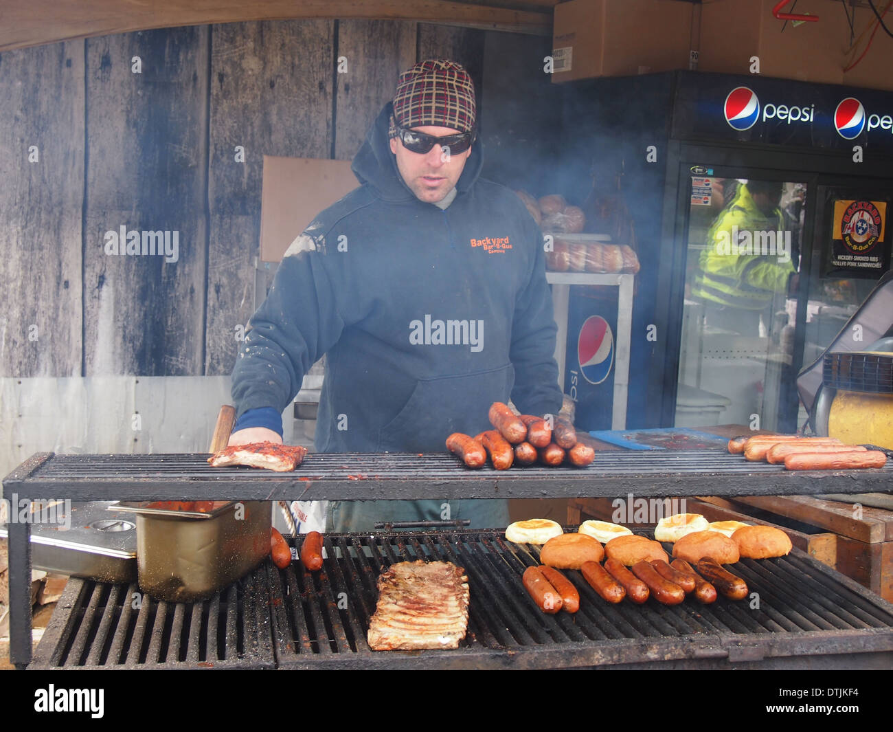 La cuisine l'homme utdoor barbecue avec des hot-dogs Banque D'Images