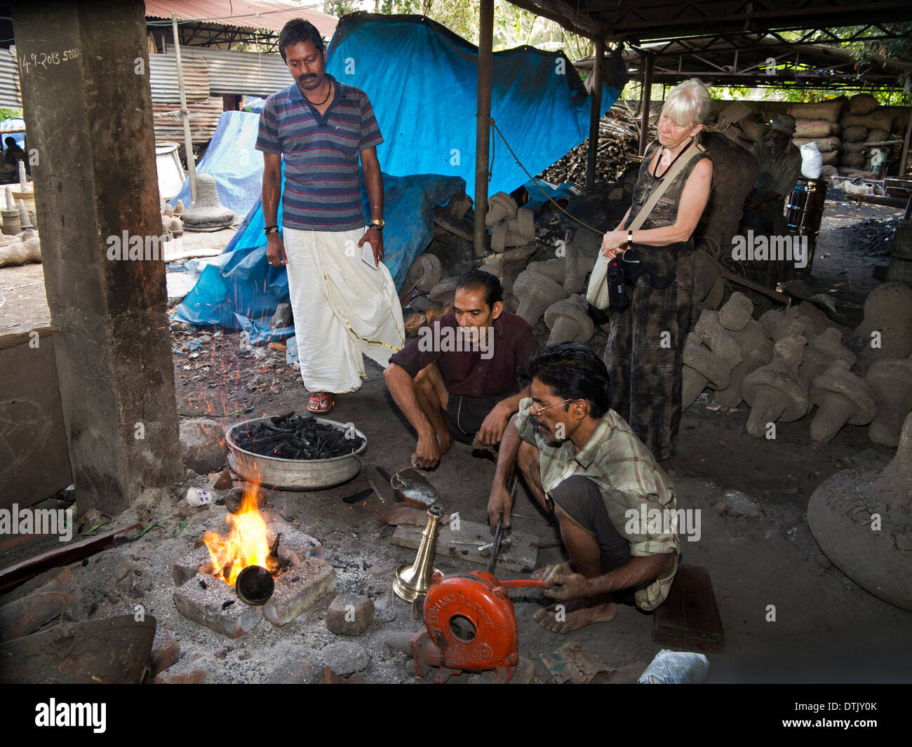 L'Inde, le Kerala, Mannar, fonderie, femme occidentale visiteur à la forge à l'effeuillée manuellement Banque D'Images