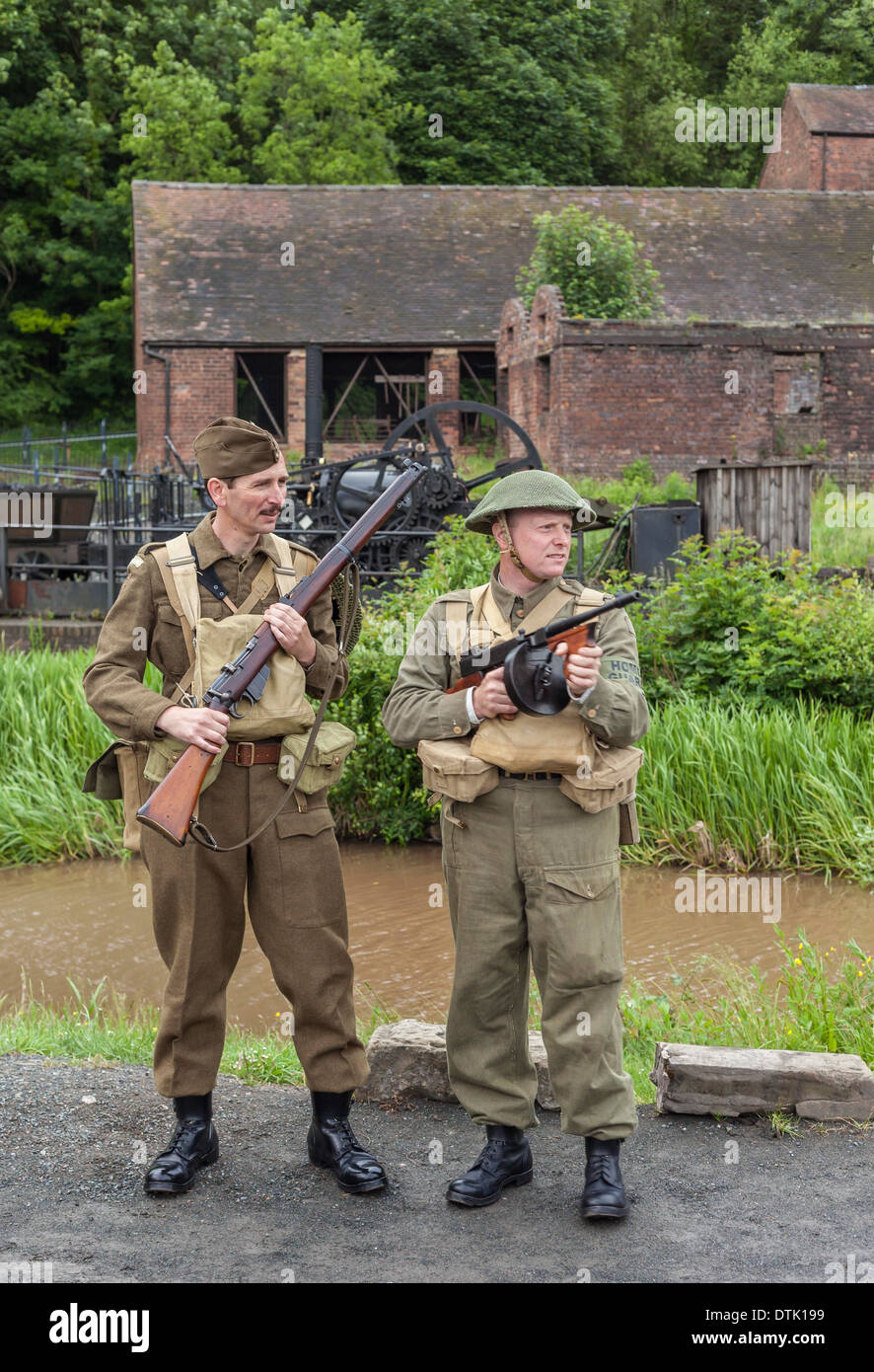 Deux jeunes hommes habillés en adultes dans la seconde guerre mondiale uniforme de la garde à domicile dans le cadre de reconstitution des années 40. Banque D'Images