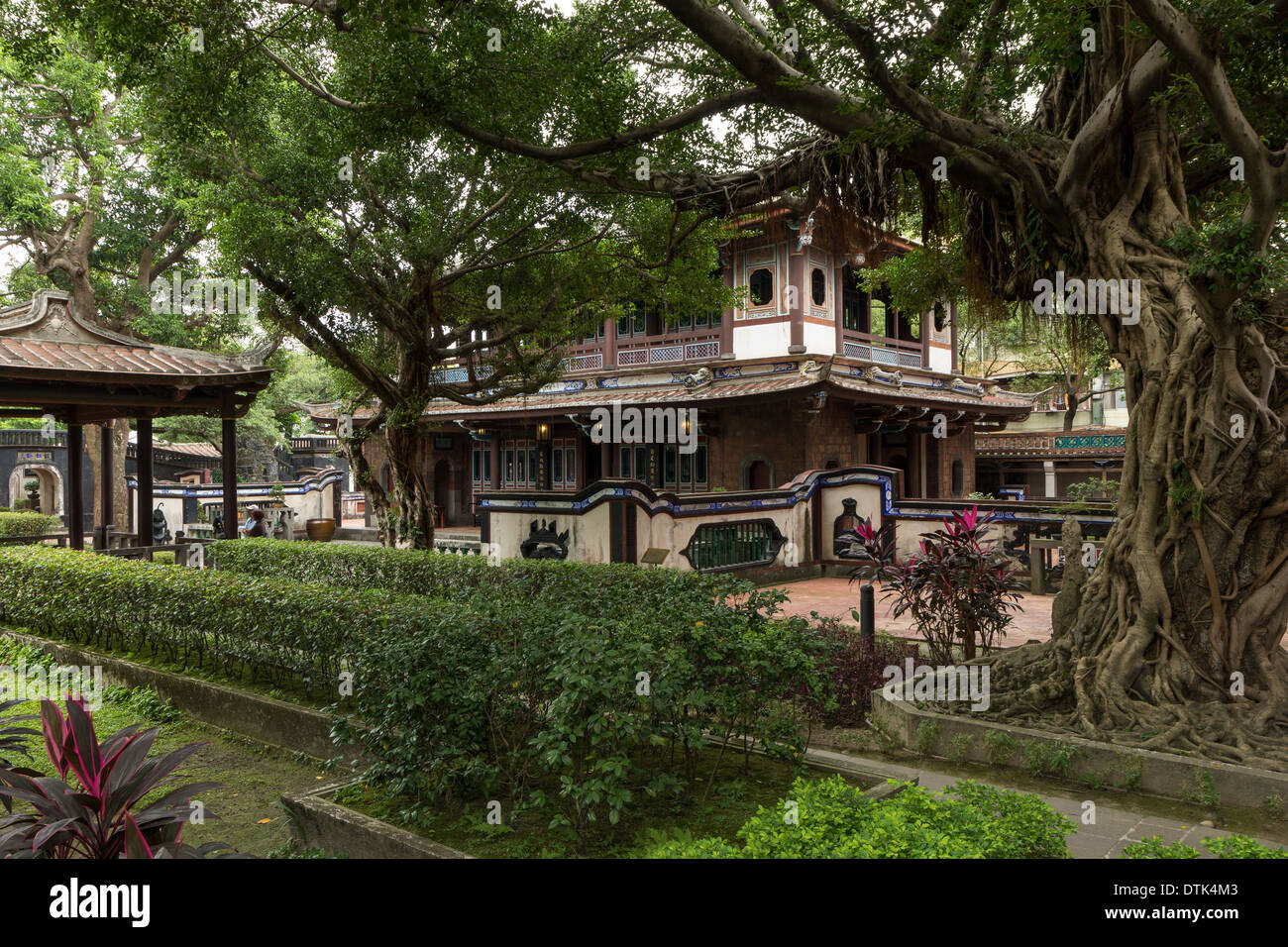 Ancien bâtiment traditionnel chinois à un jardin avec de grands arbres Banque D'Images