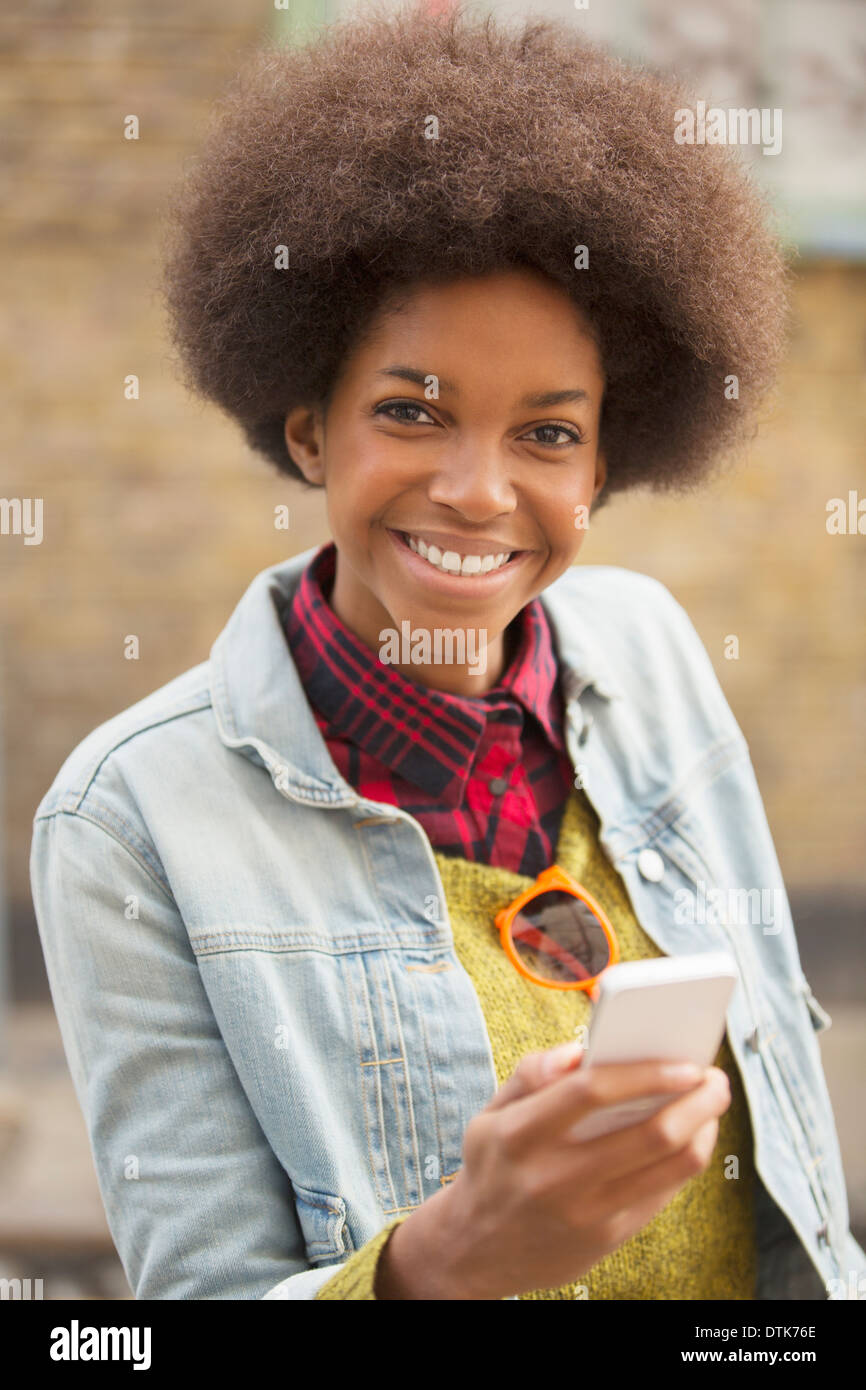 Woman using cell phone outdoors Banque D'Images