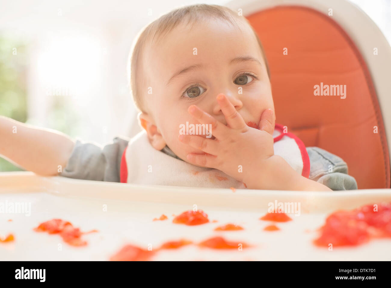 Baby Boy eating dessert la gélatine dans une chaise haute Banque D'Images