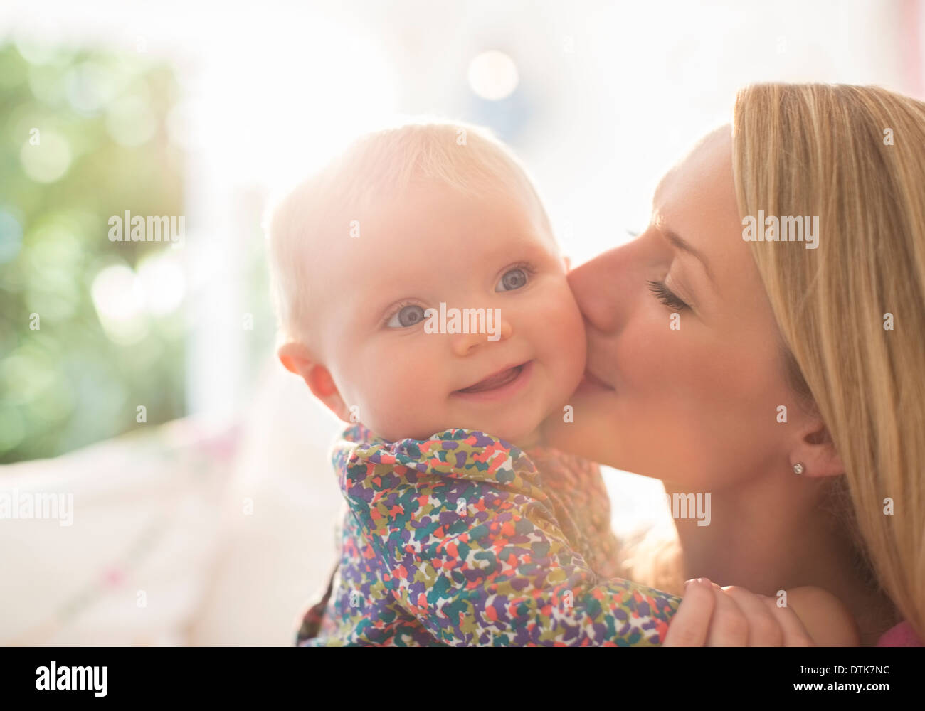 Mère embrassant la joue de bébé fille Banque D'Images