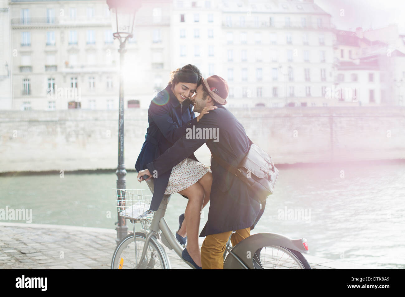 Couple hugging on à vélo le long de la rivière Seine, Paris, France Banque D'Images