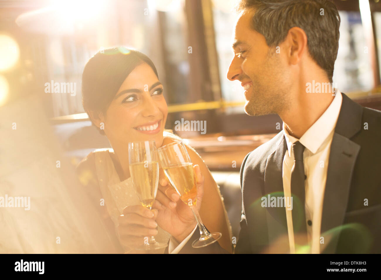 Bien-habillé couple toasting with champagne flutes in restaurant Banque D'Images