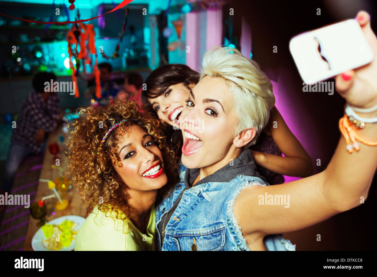 Women Taking self-portrait at party Banque D'Images