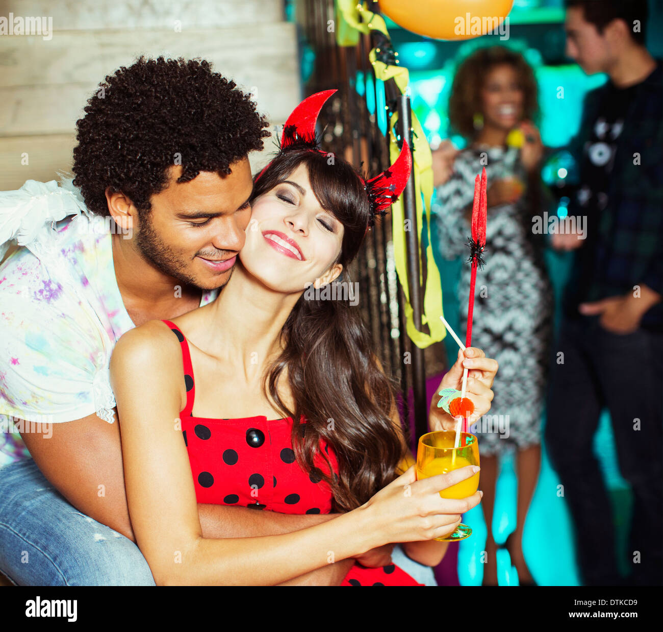 Man hugging girlfriend at party Banque D'Images